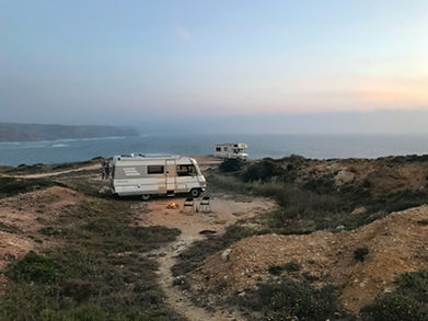 Camper auf einem schönen Platz an einer Klippe mit Blick auf das Meer im Sonnenuntergang