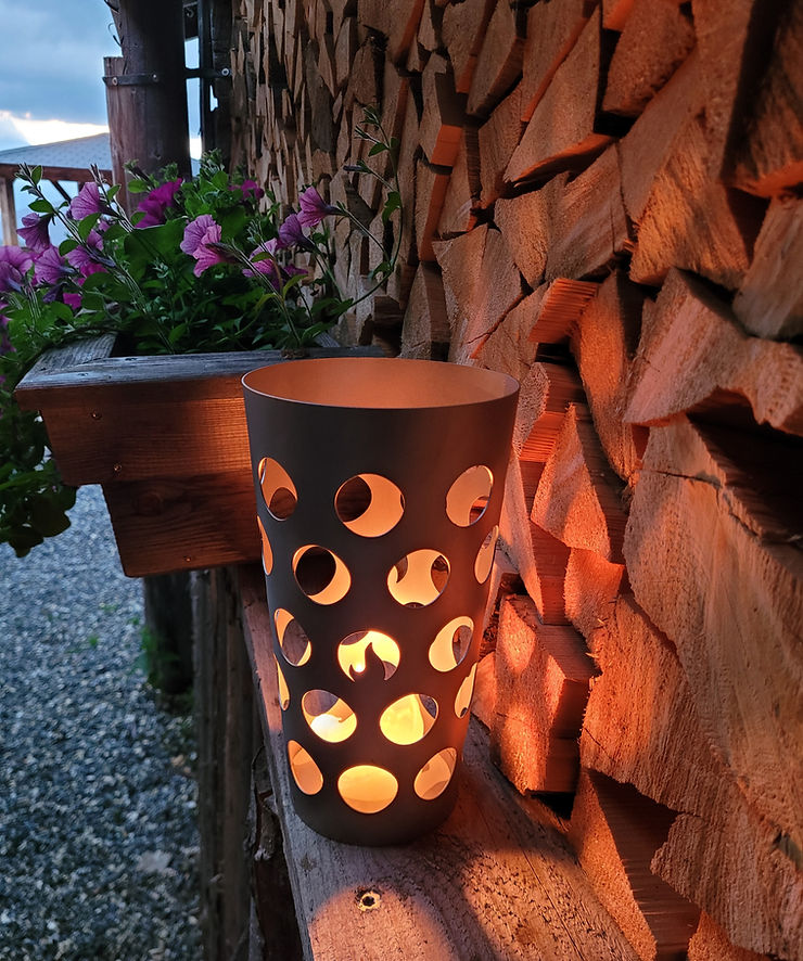 Dubbe Windlicht in Edelstahl, draußen vor einer Holzwand